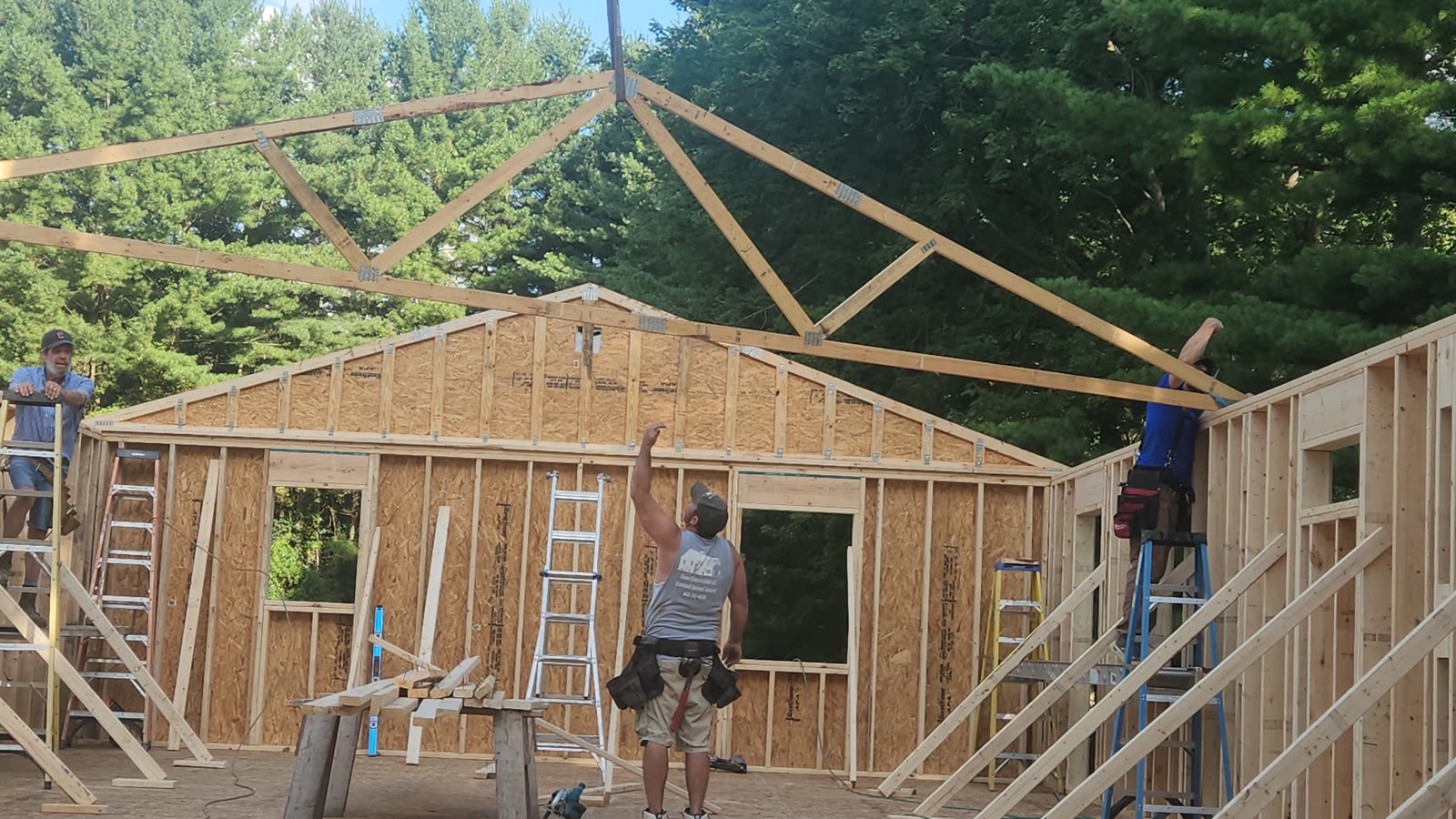 Clean Construction crew setting roof trusses on a home addition, serving Amherst Ohio